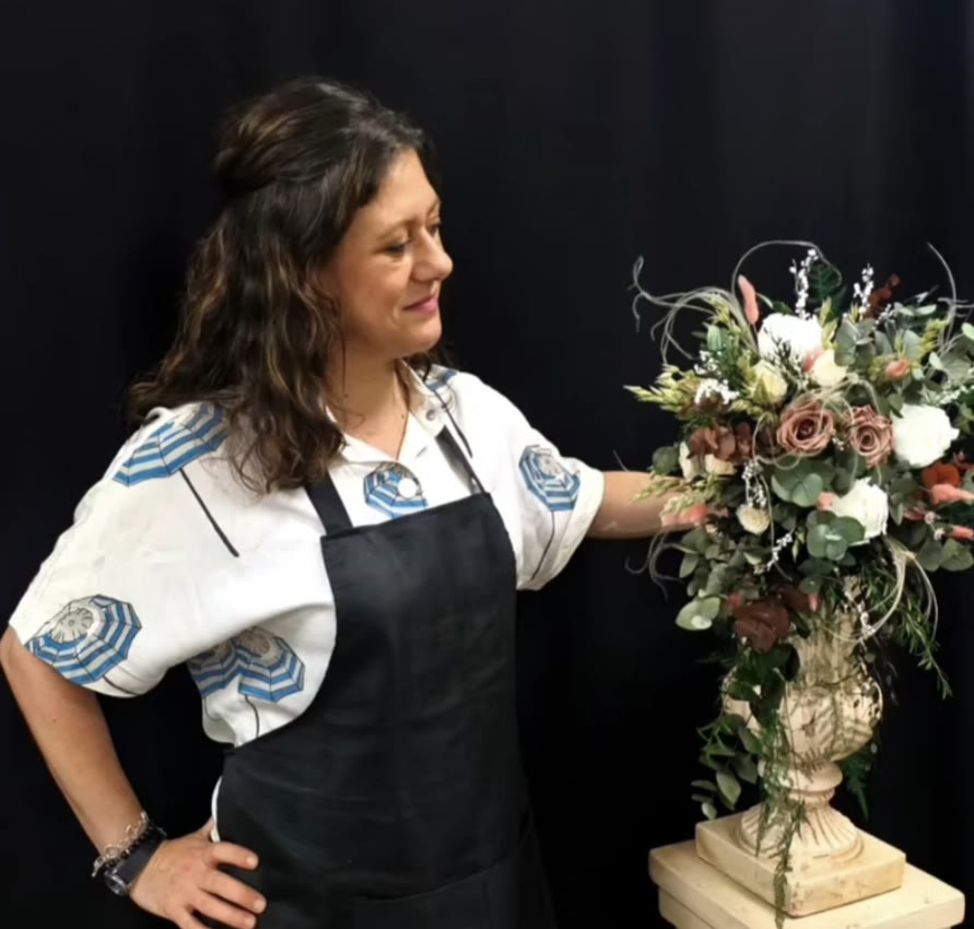 Mirela junto a un centro de flor preservada sobre un pedestal