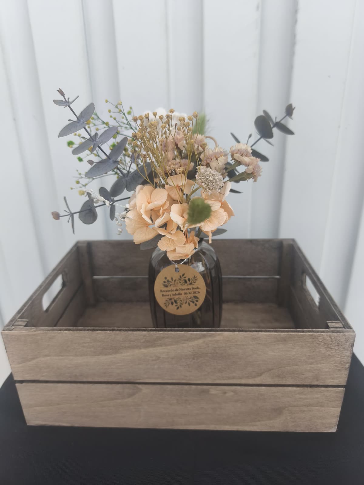 Jarrón con flor preservada y etiqueta de recuerdo de boda
